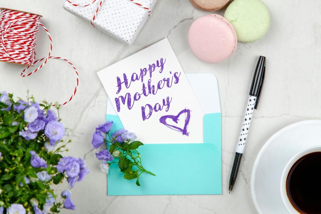 Creative Mother's Day card setup with flowers, coffee, and macarons on a marble table.